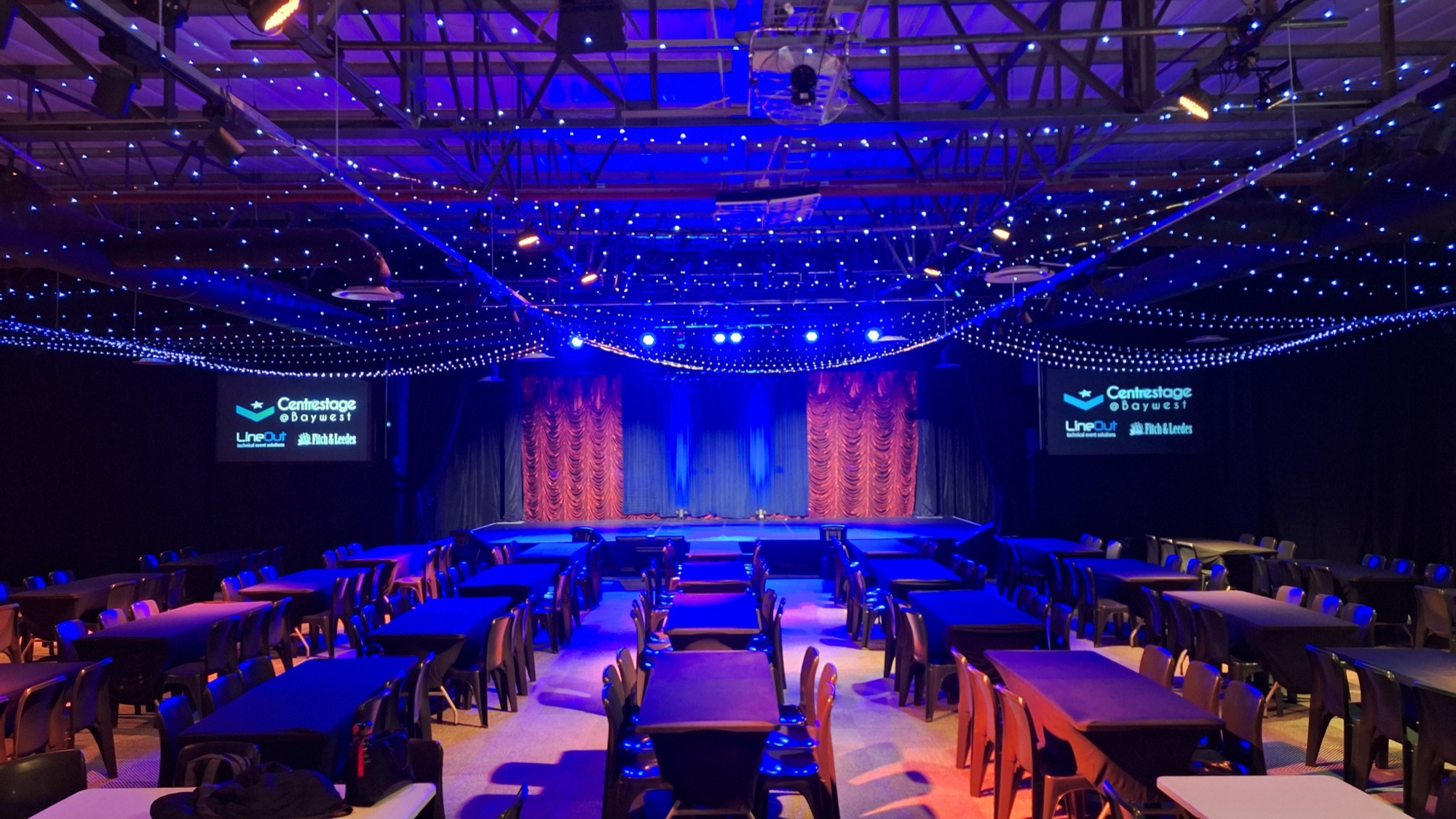 Centrestage@Baywest stage and dinner-theatre seating under blue lights